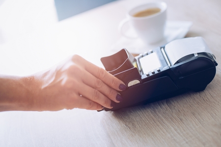 Woman paying with credit card in cafe. Credit card payment