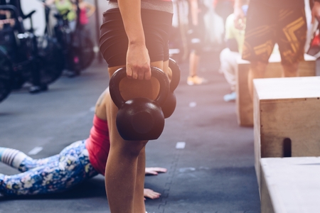 Woman training with kettlebell weights at the gymの写真素材