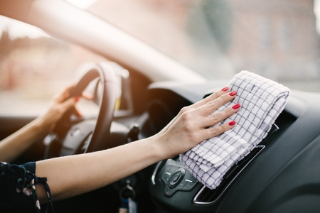 Woman cleaning car dashboard. Modern car interiorの写真素材