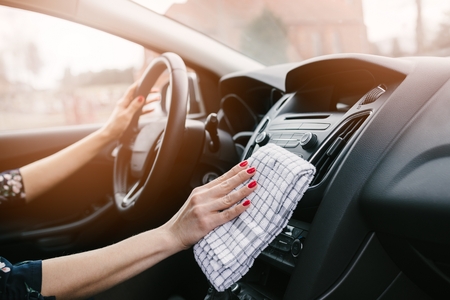 Woman cleaning car dashboard. Modern car interiorの写真素材