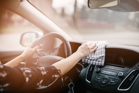 Woman cleaning car dashboard. Modern car interiorの写真素材
