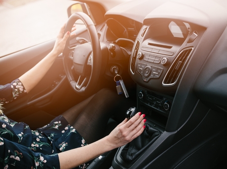 Young woman changing gears in car. Driving a car. Manual transmission. Modern car interiorの写真素材