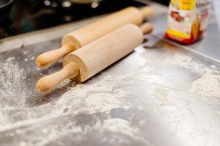 Two wooden rolling pins on the tableの写真素材