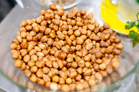 Raw hazelnuts in the glass bowl in the kitchenの写真素材