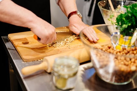 Man cutting walnuts on the cutting board in the kitchenの写真素材
