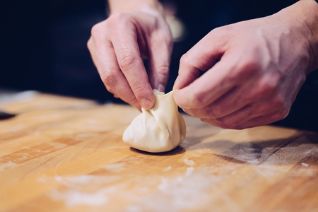 Man hands making khinkali. Traditional Georgian dumplings with meat. Georgian foodの写真素材