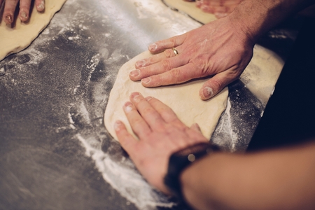 Male hands making pizza dough on the tableの写真素材
