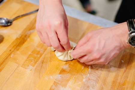 Man hands making khinkali. Traditional Georgian dumplings with meat. Georgian foodの写真素材