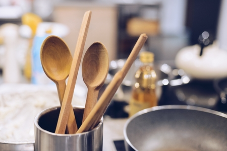 Wooden spoon in metal container in the kitchenの写真素材