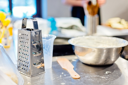 Metal grater on the cooking table in the kitchenの写真素材