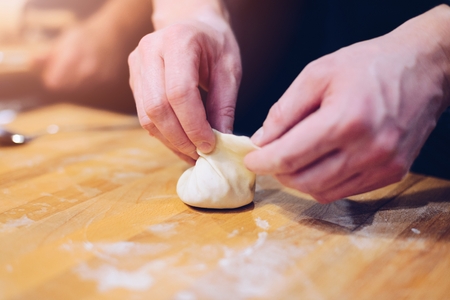 Man hands making khinkali. Traditional Georgian dumplings with meat. Georgian foodの写真素材