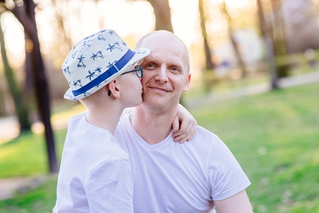 Son kissing his father. Father's Day. Happy family in the parkの写真素材