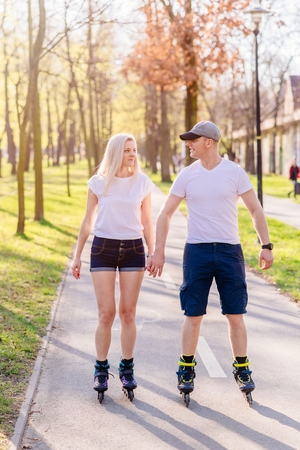 Couple roller skating on the park road. Happy family in the parkの写真素材