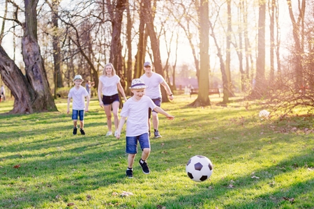 Family playing football in park. Happy family in the parkの写真素材