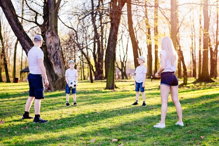 Family throwing ball on green grass in park. Happy family in the parkの写真素材
