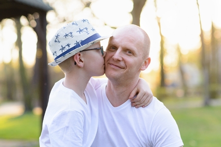 Happy child son kissing father. Father's Day. Happy family in the parkの写真素材