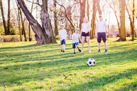 Family playing football in park. Happy family in the parkの写真素材