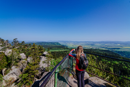 Woman tourist taking photo of Szczeliniec Wielki mountain. Sudety mountains in Polandの写真素材