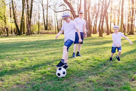 Family playing with ball on grass meadow. Happy family in the parkの写真素材