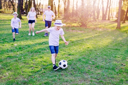 Family playing football in park. Happy family in the parkの写真素材