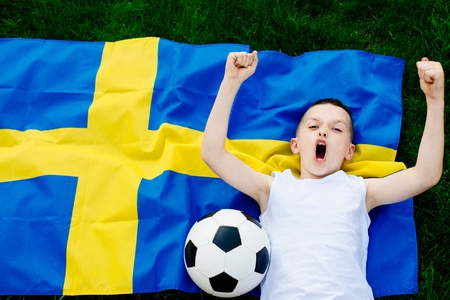 Sweden national football team. Child boy with football ball and Swedish flagの写真素材
