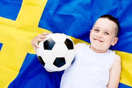 Sweden national football team. Child boy with football ball and Swedish flagの写真素材