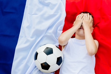 Disappointed France national football team. Child boy with football ball and French flagの写真素材