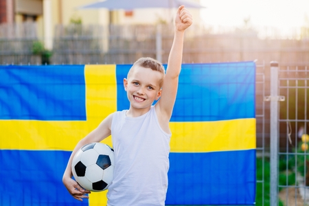 Sweden national football team supporter. Child boy with football ball and Sweden flagの写真素材