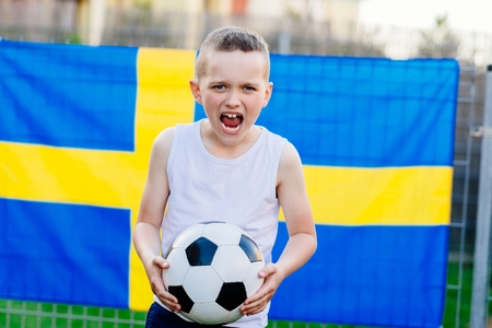 Sweden national football team supporter. Child boy with football ball and Sweden flagの写真素材