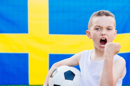 Sweden national football team supporter. Child boy with football ball and Sweden flagの写真素材