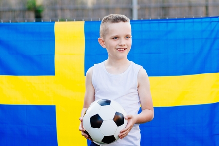 Sweden national football team supporter. Child boy with football ball and Sweden flagの写真素材