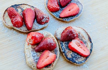 Fried pancakes with strawberries and powdered sugarの写真素材