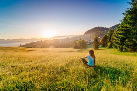 Female enjoying life at sunny morning. Happy young woman at mountains. Relaxation conceptの写真素材
