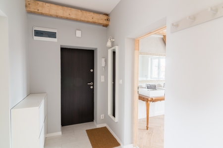 Modern apartment hall with entrance doors and intercom. Grey wall. Modern, bright attic apartment.の写真素材