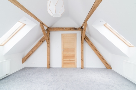 Empty attic room with wooden ceiling beams. Modern, bright attic apartment.の写真素材
