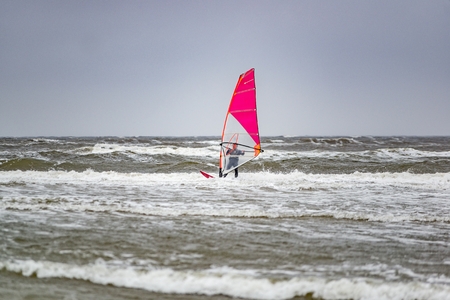 Man windsurfing on cloudy windy cold day on Romo Island in Denmarkの写真素材
