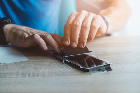 Man applying protective screen protector on his smartphone touchscreenの写真素材
