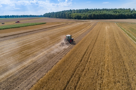 Tractor plowing field after harvesting. Farm worksの写真素材
