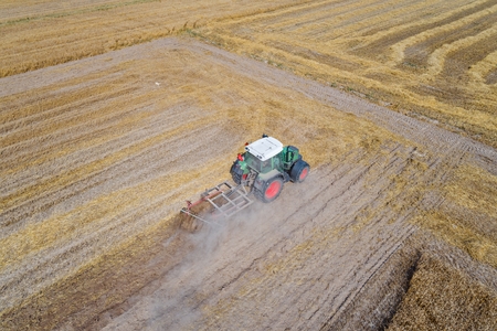 Tractor plowing field after harvesting. Farm worksの写真素材