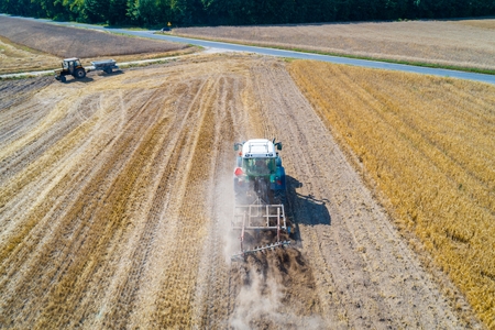 Tractor plowing field after harvesting. Farm worksの写真素材