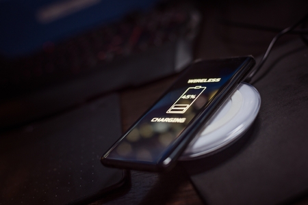 Touchscreen smartphone wireless charging on induction charger. Wireless chargerの写真素材