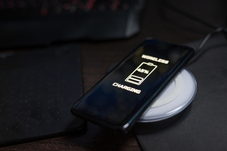 Touchscreen smartphone wireless charging on induction charger. Wireless chargerの写真素材