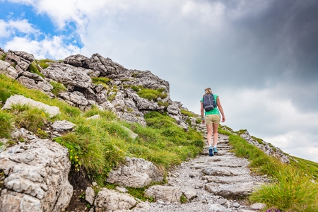 Woman walking on mountain trail in Polish Tatra mountainsの写真素材