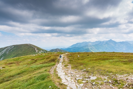 Woman walking on mountain trail in Polish Tatra mountainsの写真素材