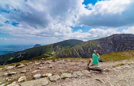 Young woman resting on mountain track in Polish Tatra mountainsの写真素材