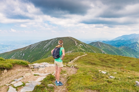 Woman walking on mountain trail in Polish Tatra mountainsの写真素材