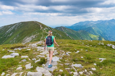 Woman walking on mountain trail in Polish Tatra mountainsの写真素材