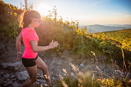 Beautiful young woman running in mountains. Woman trail runner. Szczyrk, Beskidy Mountains, Polandの写真素材