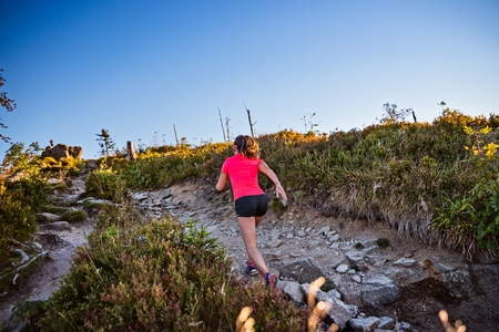 Beautiful young woman running in mountains. Woman trail runner. Szczyrk, Beskidy Mountains, Polandの写真素材