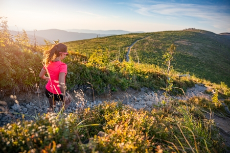 Beautiful young woman running in mountains. Woman trail runner. Szczyrk, Beskidy Mountains, Polandの写真素材